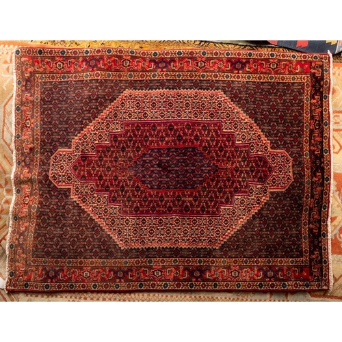 1088 - A Senneh rug, the geometric lozenge design field with a central stepped and pointed hexagonal medall... 