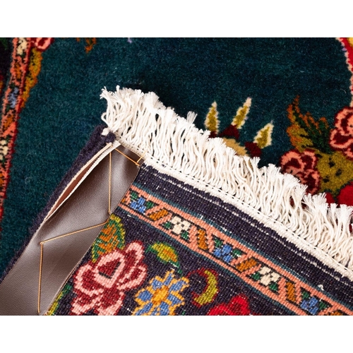 1090 - A Sarouk runner, the green field with twin ivory scrolling cartouche pointed medallions with floral ... 