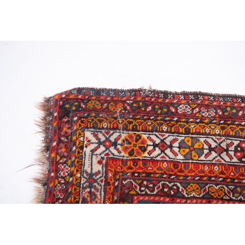 1091 - A South Persian runner, the red field with indigo hooked and stepped and geometric medallions, all o... 