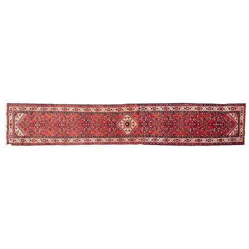 1092 - A Melayer runner, the brick red pointed field with a central ivory stepped lozenge flowerhead medall... 