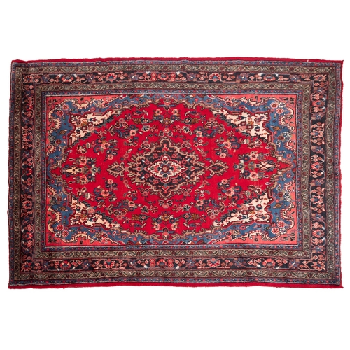 1095 - A Hamadan carpet, the red shaped lozenge field with a central indigo lozenge pole medallion, all ove... 