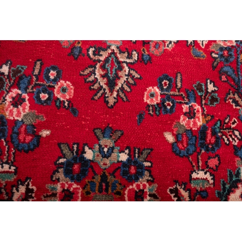 1095 - A Hamadan carpet, the red shaped lozenge field with a central indigo lozenge pole medallion, all ove... 