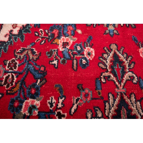 1095 - A Hamadan carpet, the red shaped lozenge field with a central indigo lozenge pole medallion, all ove... 