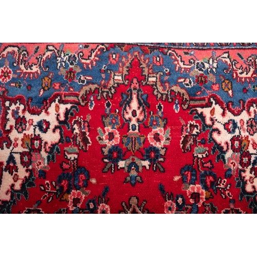 1095 - A Hamadan carpet, the red shaped lozenge field with a central indigo lozenge pole medallion, all ove... 