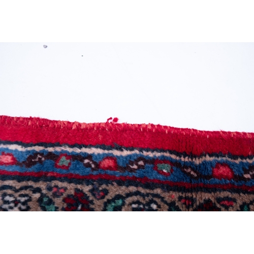 1095 - A Hamadan carpet, the red shaped lozenge field with a central indigo lozenge pole medallion, all ove... 