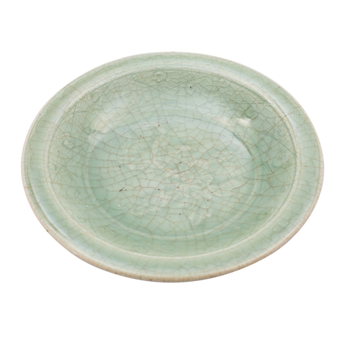 69 - A Chinese Longquan dish with crackled celadon glaze, everted rim and on short foot, moulded with a c... 