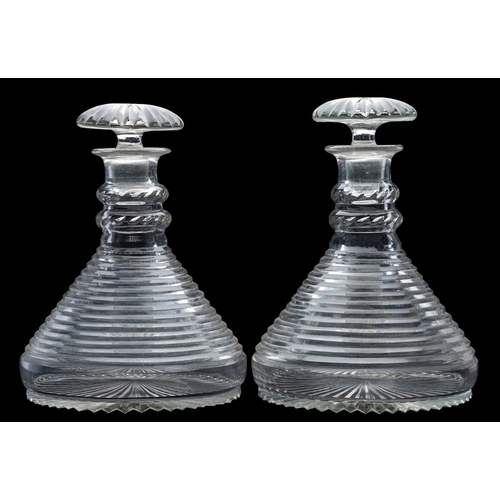 7 - A pair of cut glass ship's decanters and stoppers with double knopped stems and on star cut bases, 2... 