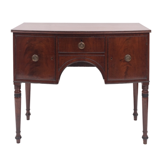 911 - A Regency mahogany and crossbanded bowfront sideboard, early 19th century; the central drawer above ... 