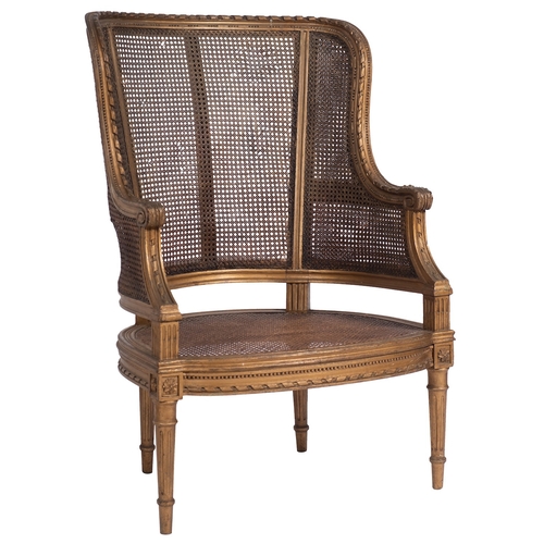 924 - A carved giltwood and canework bergere armchair in Louis XVI taste, early 20th century; the backrest... 