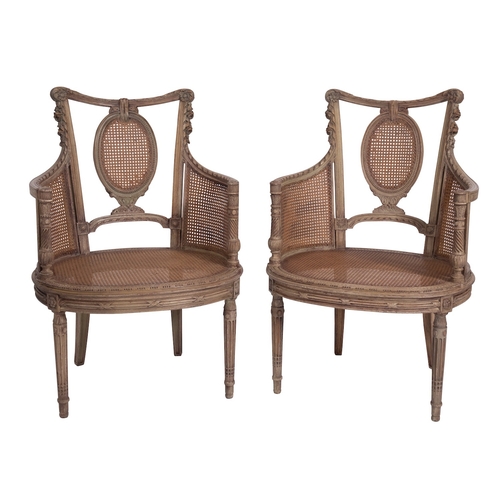 930 - A pair of carved and painted wood and canework bergere elbow chairs in Louis XVI taste, late 19th ce... 