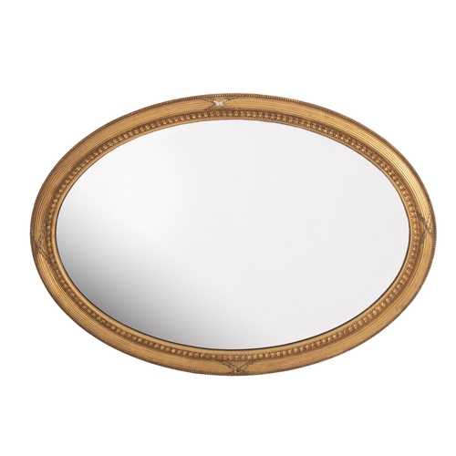 933 - A giltwood and composition framed oval wall mirror in George III Adam style, late 19th century; with... 