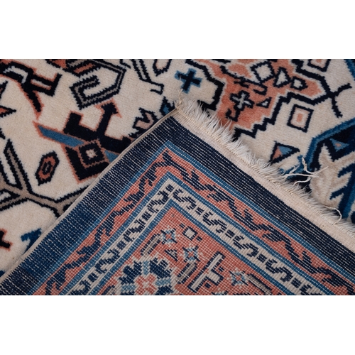 1076 - A Turkish carpet, the ivory stepped and pointed hexagonal field with rose and pastel blue flowerhead... 