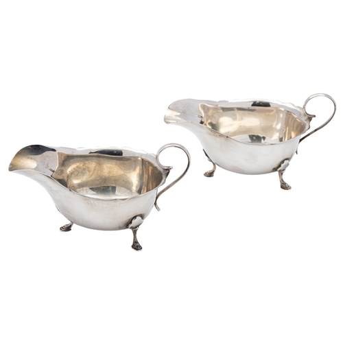 27 - A pair of silver sauce boats by Mappin & Webb, Birmingham 1920, oval with scroll handles, shaped rim... 