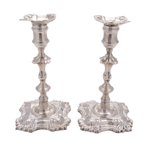 302 - A pair of late George II cast silver candlesticks by John Cafe, London 1753, shaped square with shel... 