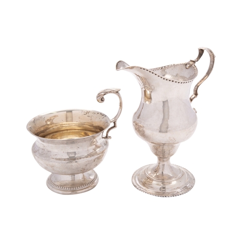 50 - A George III silver cream jug by Charles Hougham, London 1786, ogee baluster with a leaf-capped doub... 