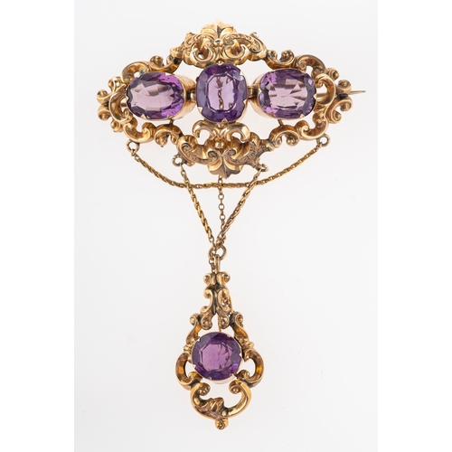 510 - A Victorian amethyst brooch, circa 1870, the openwork scrolled brooch with engraved foliate detail s... 