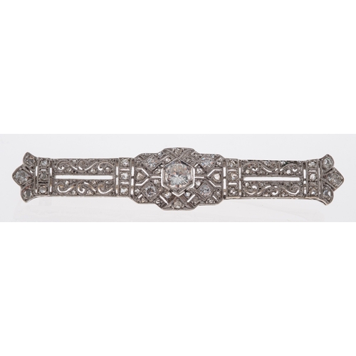 527 - An early 20th century diamond brooch, the panel with pierced scroll detail, set with a central old b... 