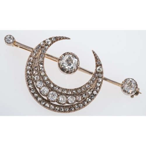 563 - An Edwardian diamond set sun and moon brooch, set with old cut stones, the principle diamond estimat... 