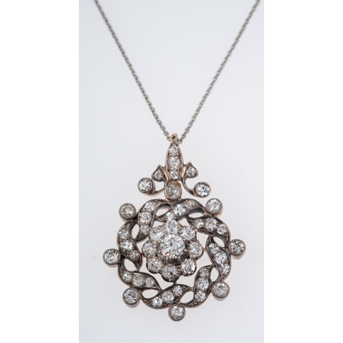 568 - An antique diamond pendant C1910, the central floral setting with a diamond of 0.33 carats, silver a... 