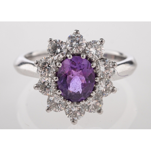 710 - A platinum, purple sapphire and diamond ring, the central oval cut purple sapphire claw set within a... 