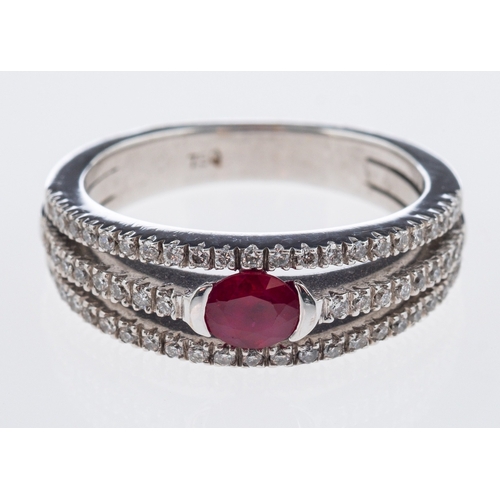 711 - A diamond and ruby ring the central oval faceted stone with split band in 18ct white gold