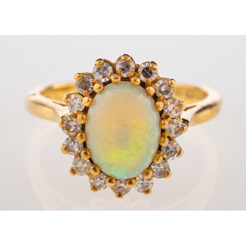 714 - An 18ct gold, opal and diamond ring, the oval cabochon opal claw set within a surround of eight cut ... 