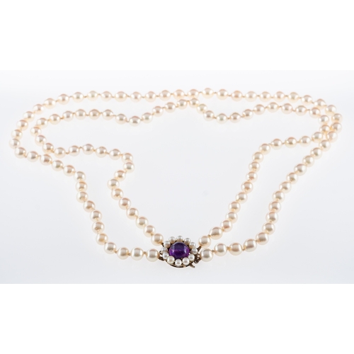 734 - A cultured pearl necklace of two rows,strung to a silver clasp set with a cabouchon amethyst., pearl... 