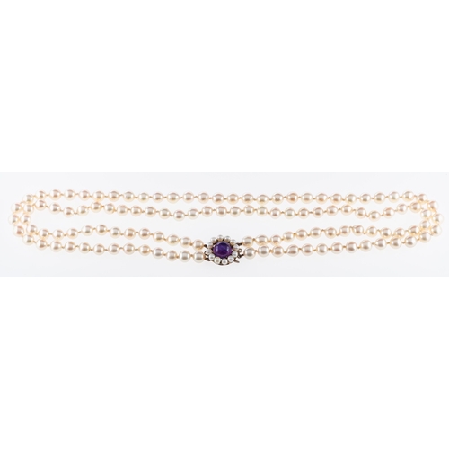 734 - A cultured pearl necklace of two rows,strung to a silver clasp set with a cabouchon amethyst., pearl... 