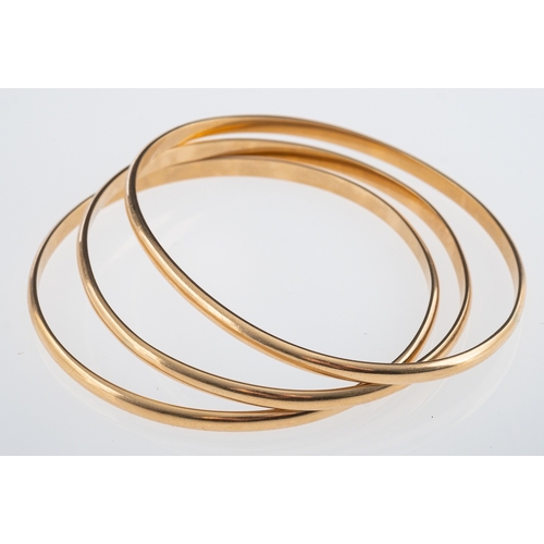 822 - Three yellow metal D form bangles, testing as 9ct gold, internal measurement 6cm, weight 34.6 grams