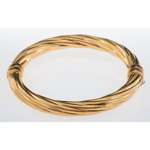 823 - A hinged bangle with twist design, 9ct gold, weight 15.2 grams