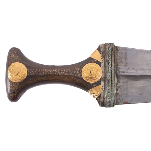 192 - An early 20th century jambiya, short curved double edged blade over a white metal mounted one piece ... 