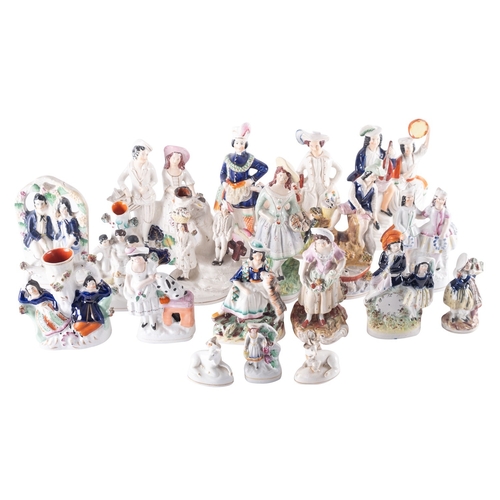 105 - A group of approximately twenty Staffordshire pottery figures, animals, spill vases, tallest 25cm hi... 