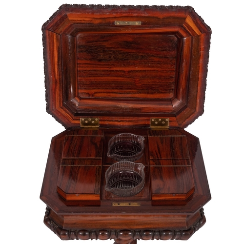 1058 - A George IV rosewood teapoy, circa 1825; the sarcophagus shaped top with hinged cover above canted a... 