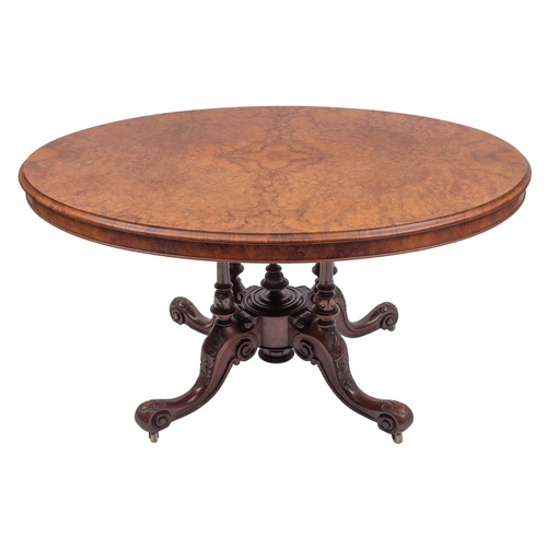 1106 - A Victorian walnut oval centre table, circa 1865; the quarter veneered flip top with moulded edges; ... 