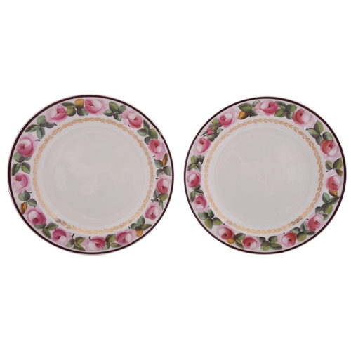 119 - A pair of early 19th century creamware plates the rims painted with pink rose sprays within chocolat... 