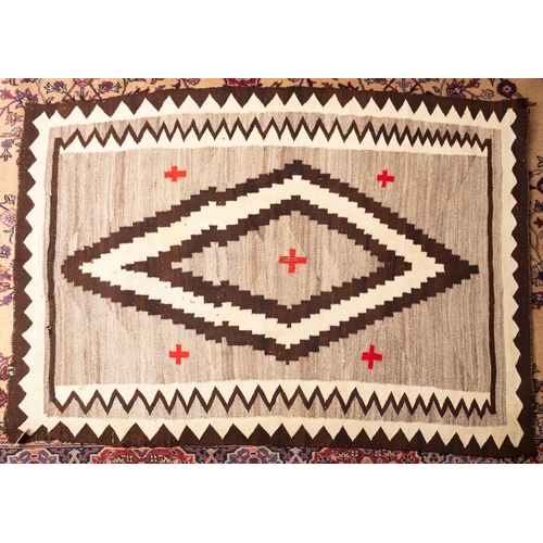 1255 - A Navajo flatweave, the beige field with a central chocolate brown and ivory lozenge medallion, encl... 