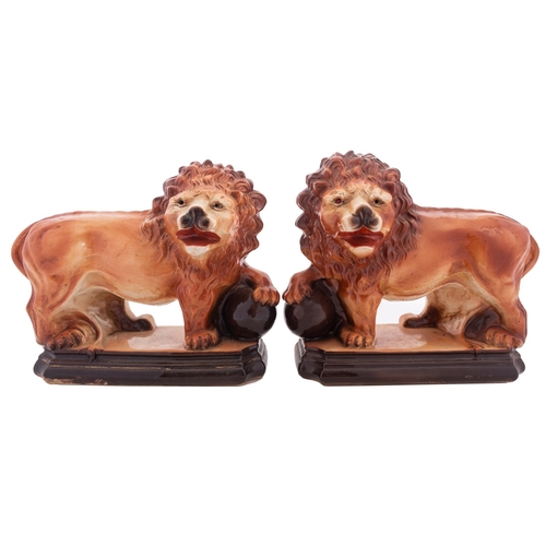 127 - A pair of Staffordshire figures of Medici lions, standing four square with head turned and with one ... 