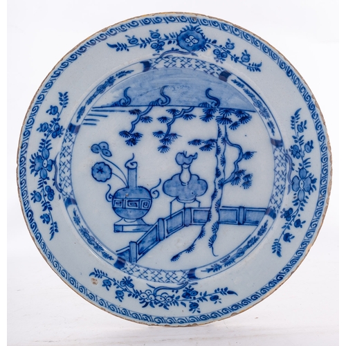 128 - A Dutch delft charger, possibly De Posteleyne Byl, painted in blue with Chinese urns and a fir tree ... 