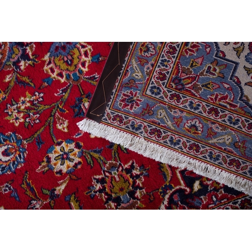 1288 - A Kashan carpet, the madder cartouche field with a central indigo shaped lozenge pole medallion, all... 