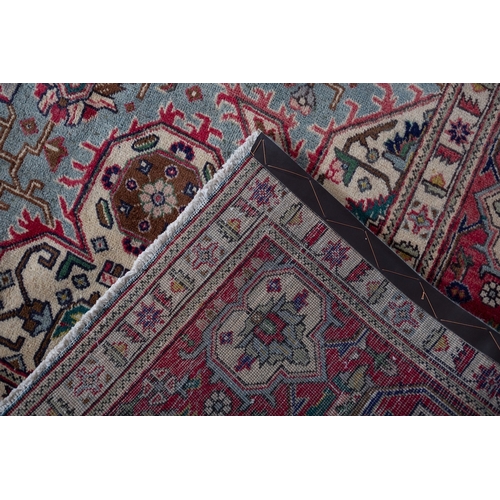 1291 - A Heriz carpet, the pastel blue field with a central rose geometric pole medallion, all over palmett... 