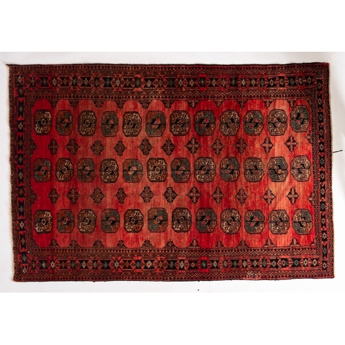 1292 - A Turkoman rug, the rose field with three rows of quartered guls, enclosed by a geometric lozenge an... 