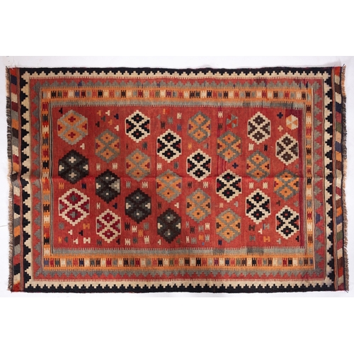 1297 - A Qashgai kilim, the brick red field with an all over design of stepped medallions enclosed by a mul... 