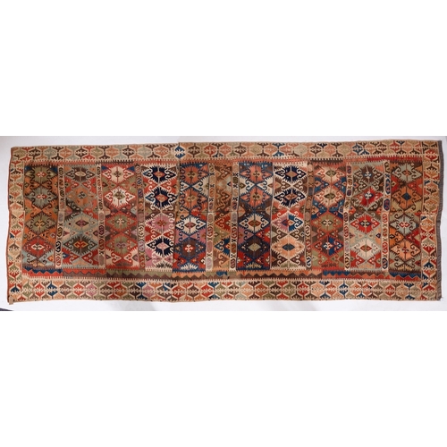 1299 - An Anatolian Kilim, the panelled field with a design of serrated lozenges in various colours, enclos... 