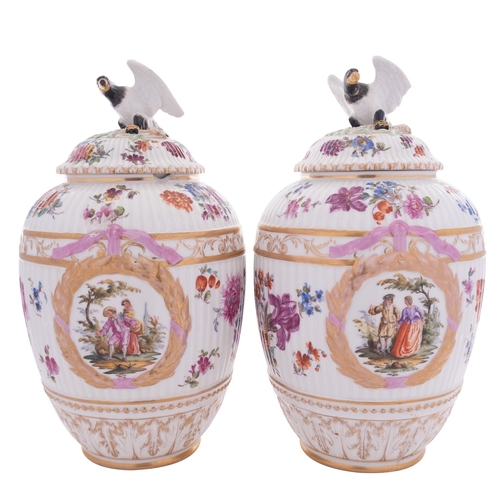 213 - A pair of Berlin porcelain jars and covers of ribbed ovoid form with eagle finials, decorated with W... 