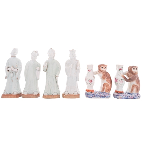 31 - Two Chinese famille rose monkey candlesticks and four celadon glazed figures of Immortals,  the cand... 