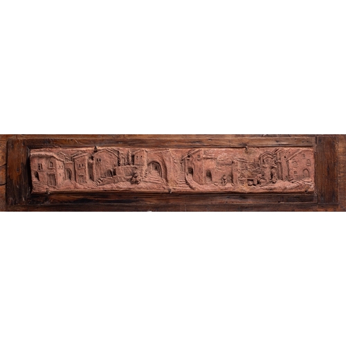 369 - An Italian terracotta plaque, decorated in deep relief with a panoramic view of a village, incised t... 