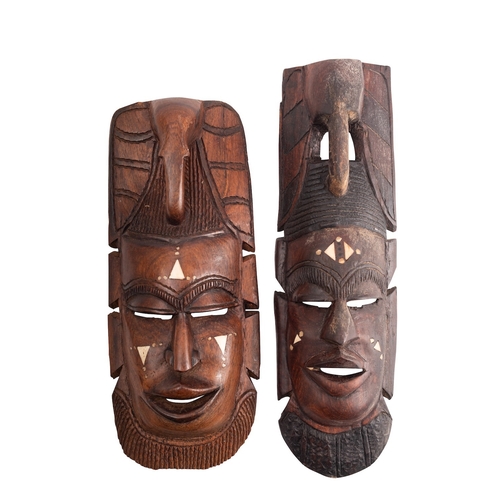 425 - Two African carved hardwood and bone inset masks, 20th century; both with stylised elephant's heads ... 