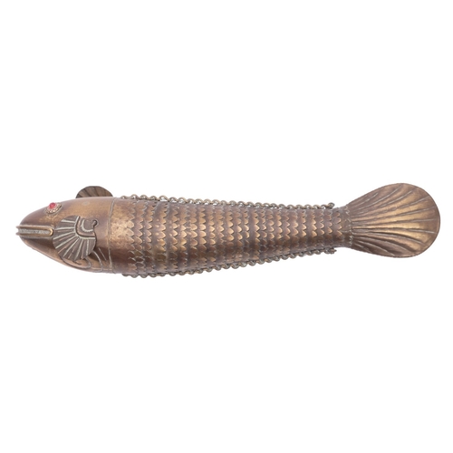 433 - An Indian brass articulated fish, early 20th century; with red glass eyes; 17.5cm long