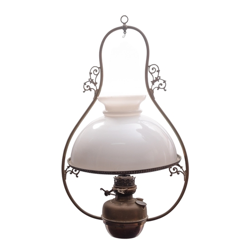 441 - A late Victorian brass and milk glass hanging oil lamp, circa 1900; the domed shade with open vent, ... 