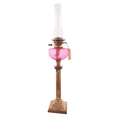 459 - A Victorian brass and glass mounted table oil lamp, late 19th century; the flue and burner above a c... 